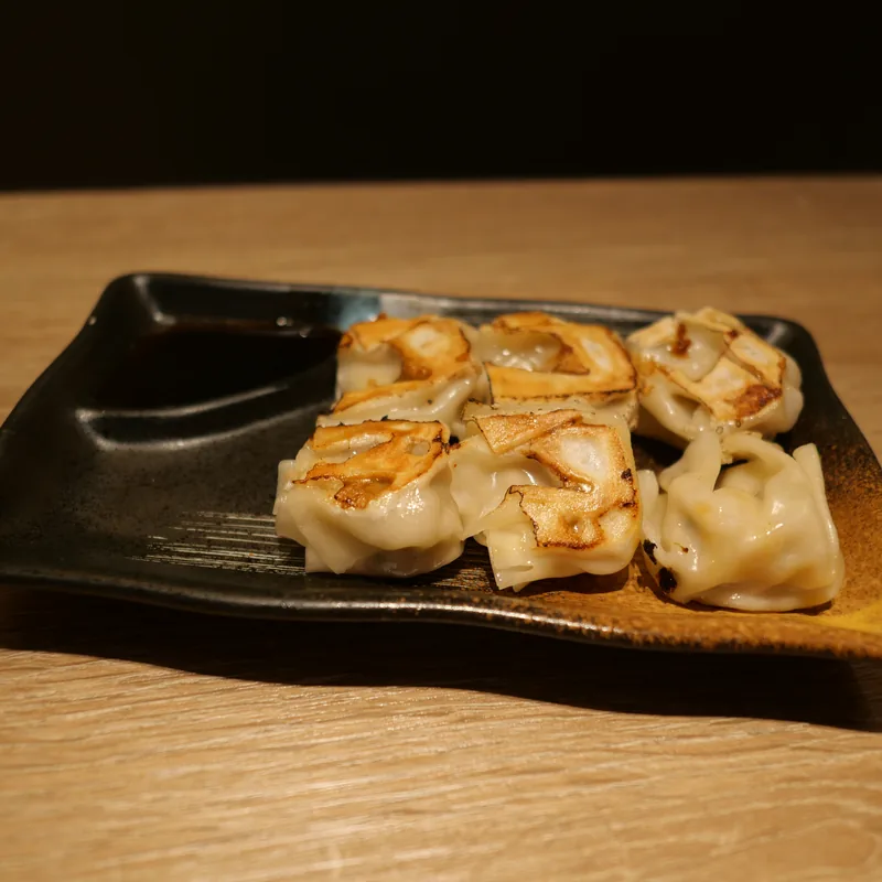Japanische Teigtaschen auf dunklem Teller
